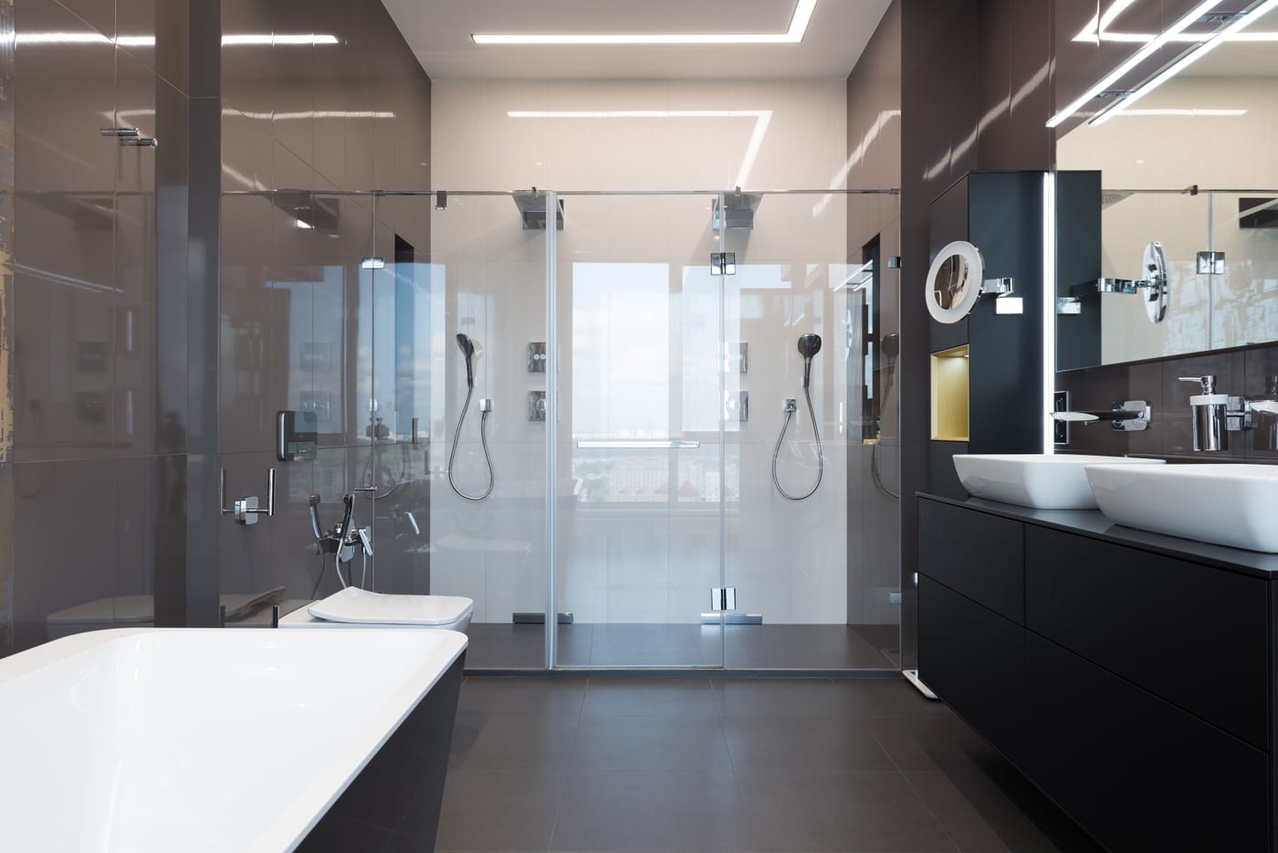 Vom Anlagenmechaniker saniertes Designbad mit Doppelwaschtisch, Glasdusche und dunklem Bodenbelag