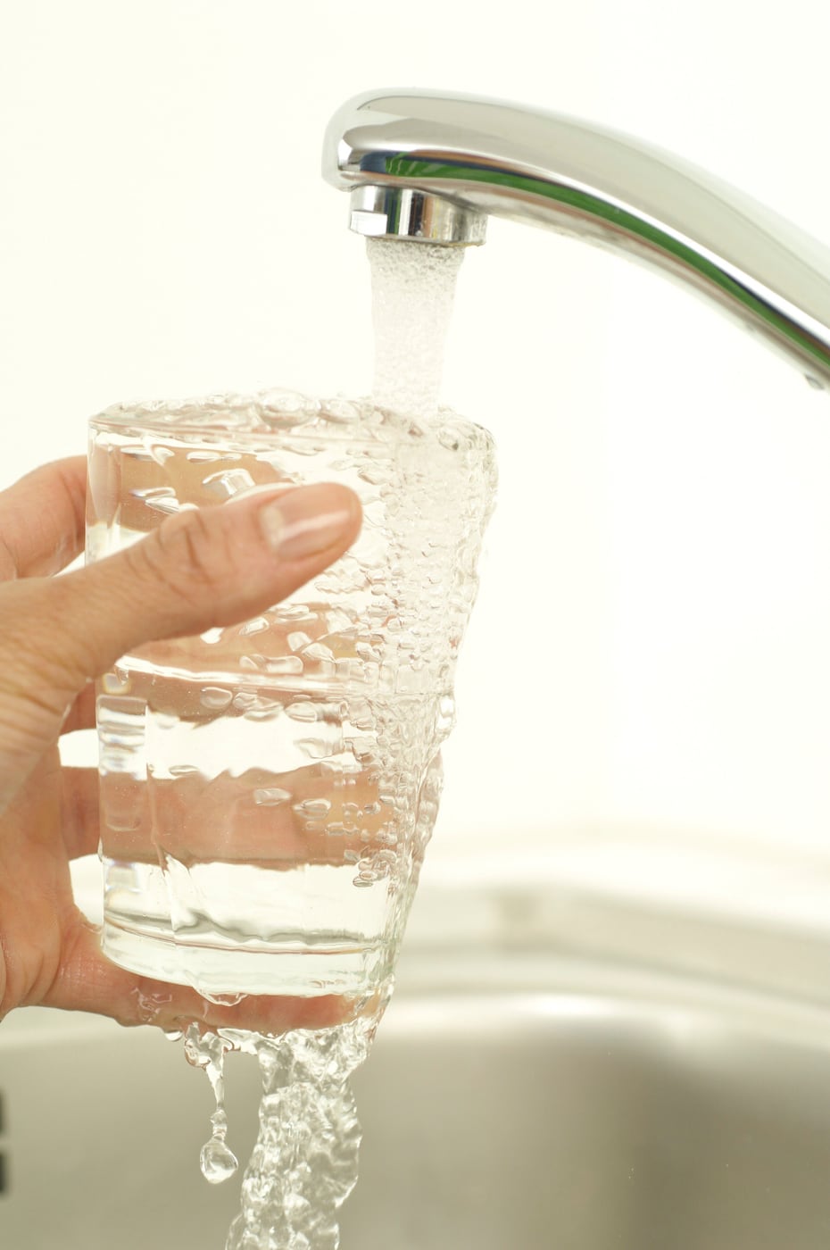 Klares Trinkwasser läuft aus dem Wasserhahn in ein Glas